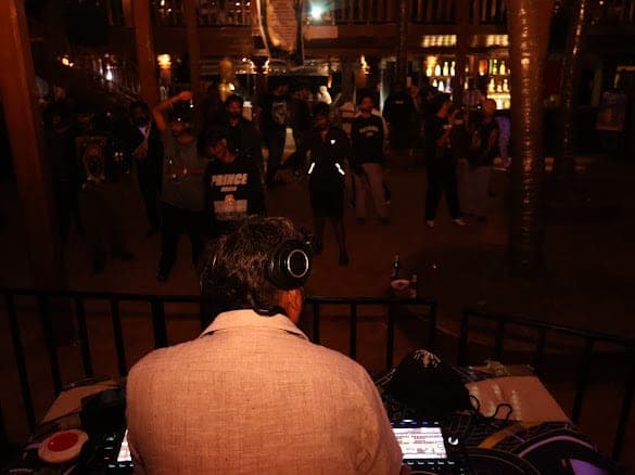 The view from behind the booth towards a crowd dancing between wooden pillars